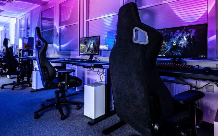 Sala con computadoras y sillas para gamers.